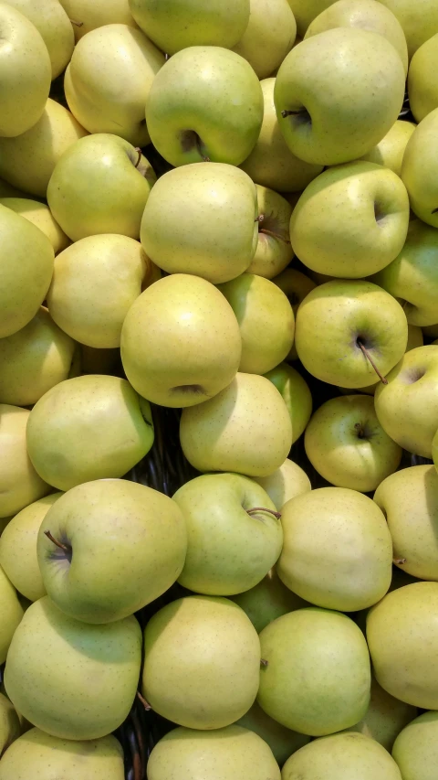 a bunch of apples sit together in a basket