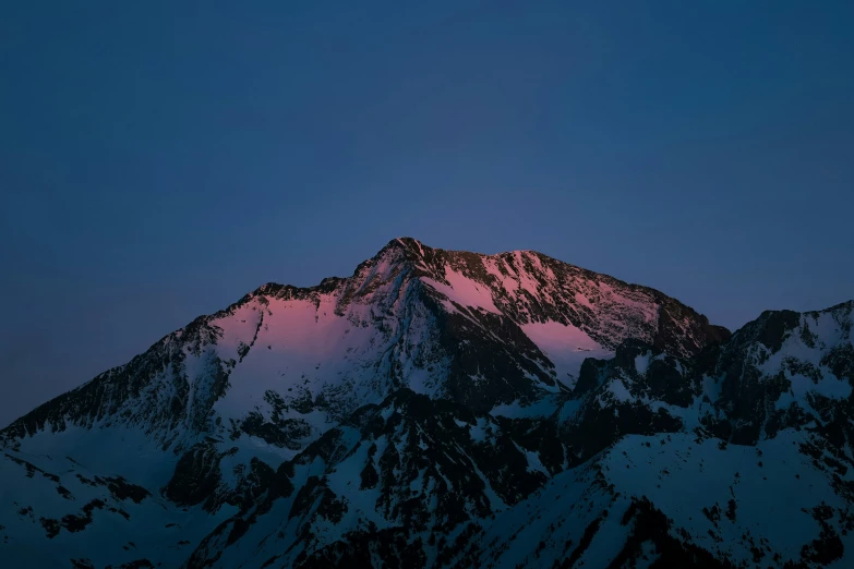 mountains covered in snow at twilight with pink sky