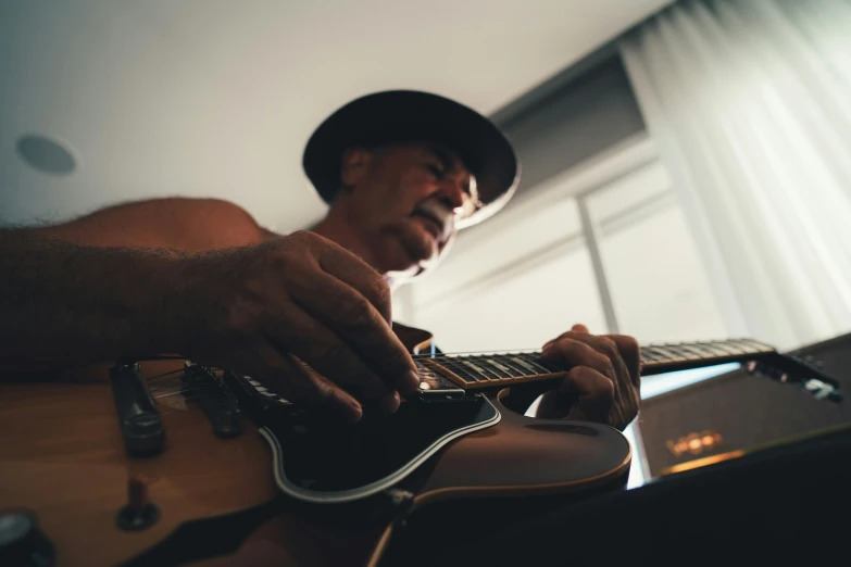 a man wearing a hat playing the guitar