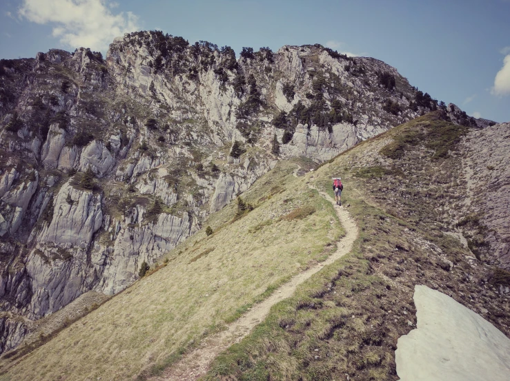 man on top of mountain ascending grassy path