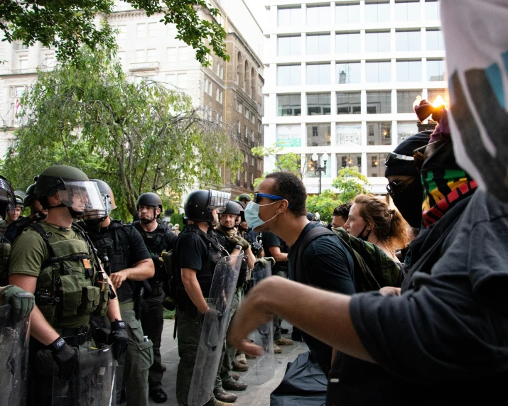 several men wearing riot gear and helmets are standing in line