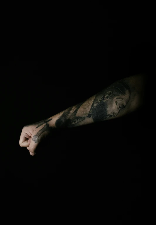 a man with arm tattoo holding onto soing