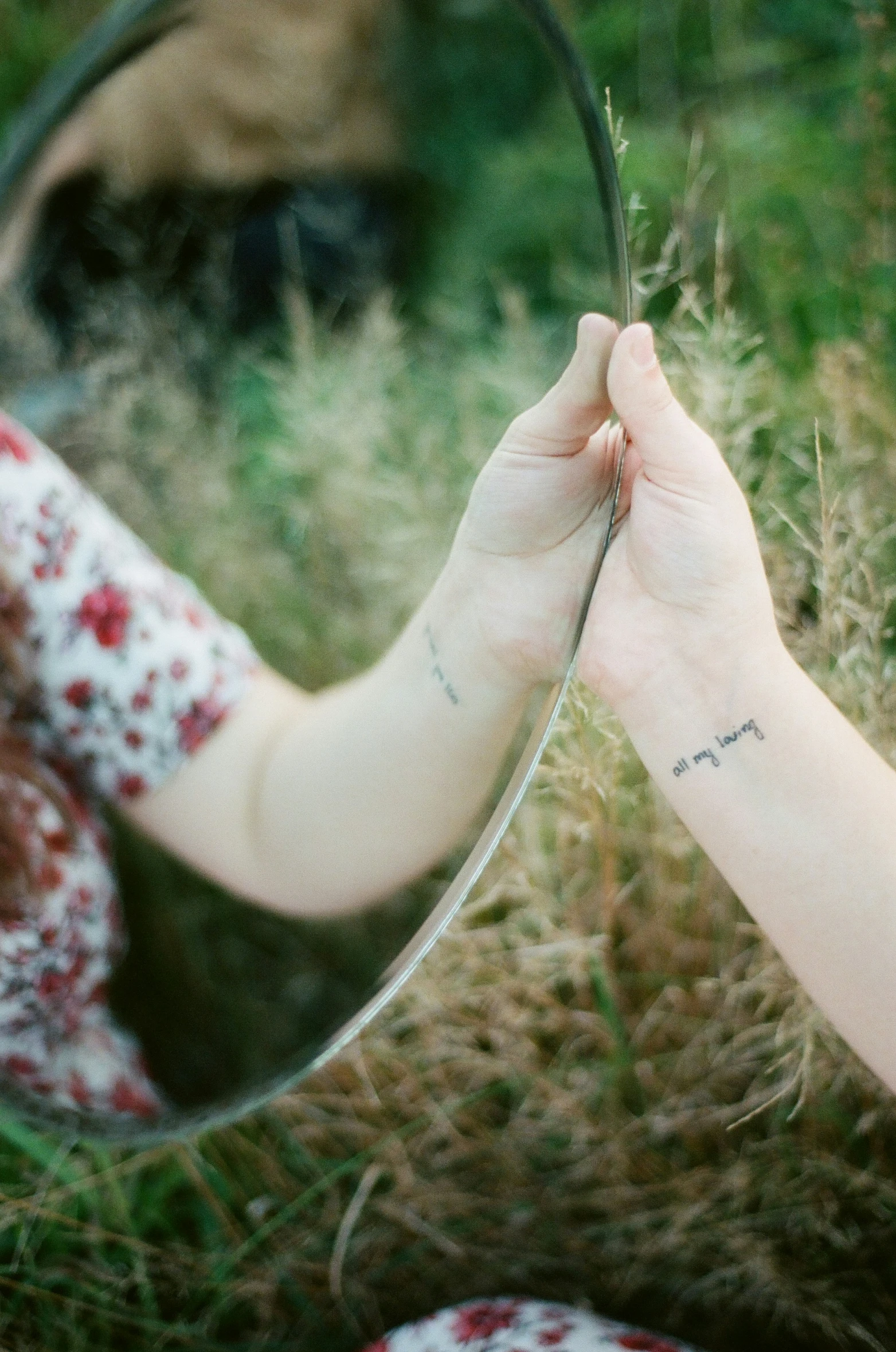 a woman has a tattoo that is in the shape of a hand holding an empty mirror