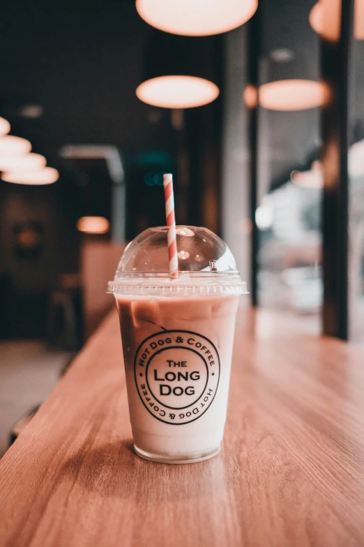 a iced coffee cup on a table with a straw