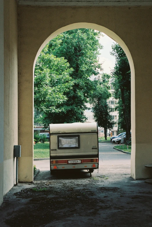 a camper van parked under a tunnel on the side of a road