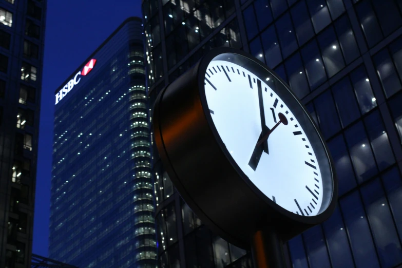 a clock with a dark background in a city at night