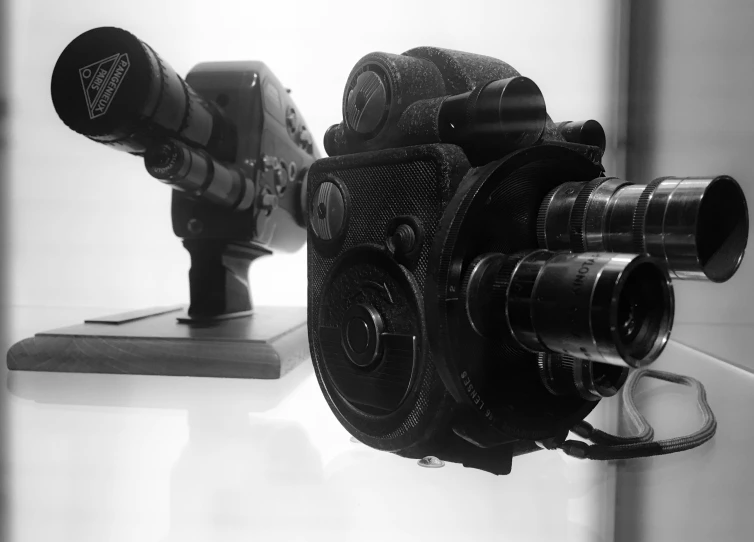 a pair of old film cameras sitting next to each other