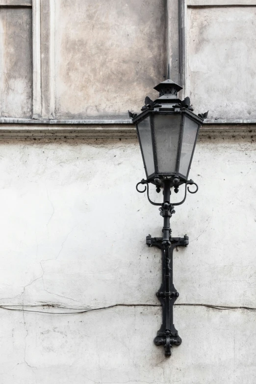 an old fashioned black light fixture on the side of a white building