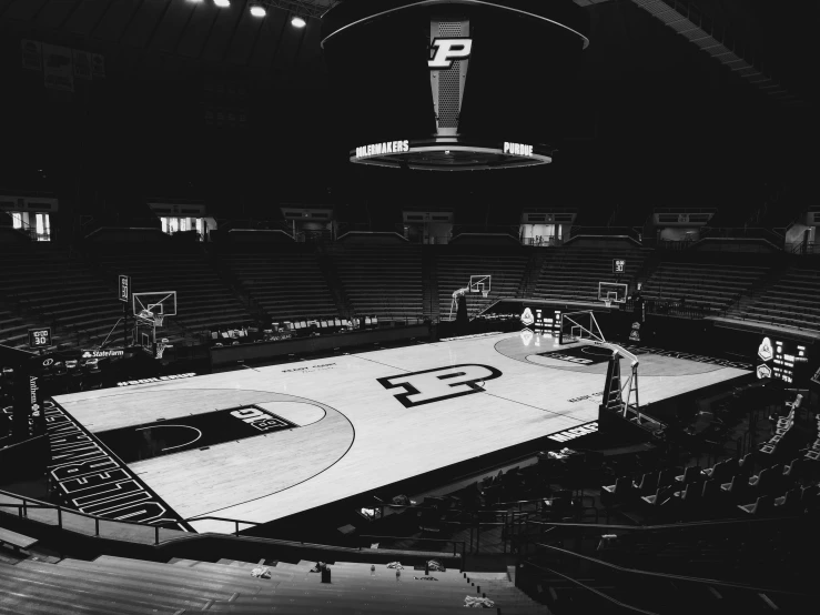 an empty basketball court at night with the lights on