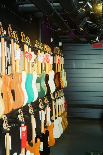 a bunch of guitars in a room with hard wood flooring