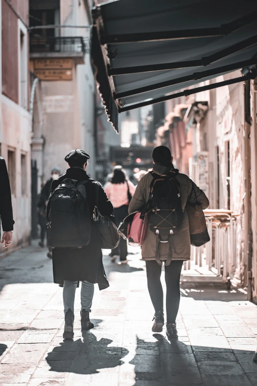 some people walking on a narrow city street