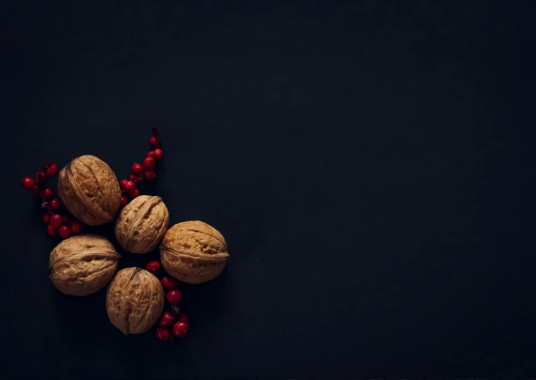 almonds and berries on black background with dark space