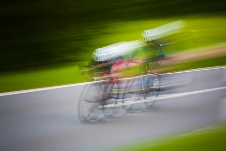 three people riding on a bike down a long street