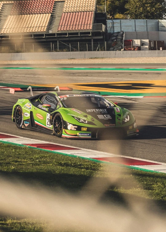 a green car is going around the corner on a race track