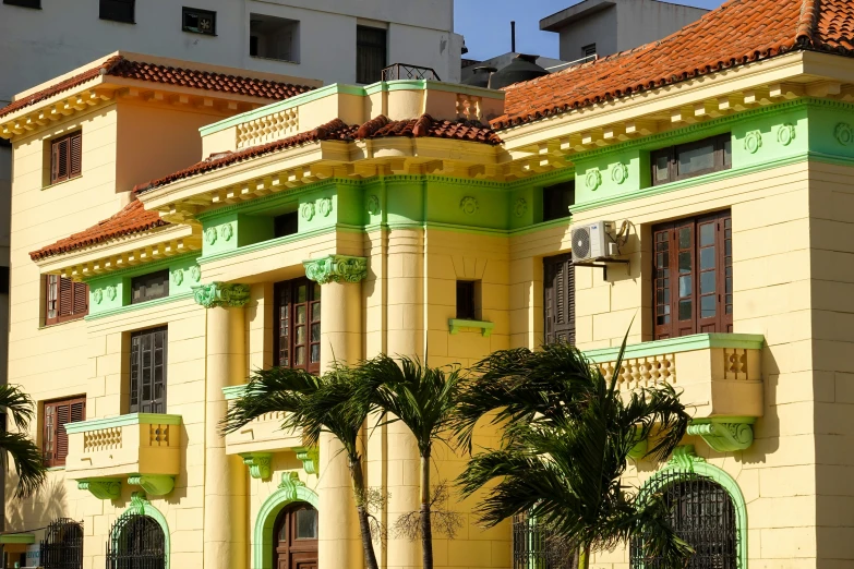 a large building with a long tower and trees in front of it