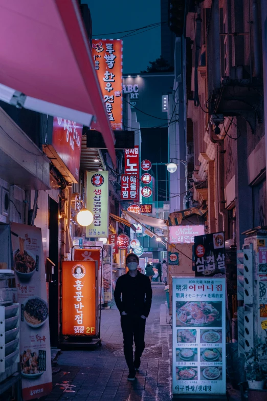 person walking down street with businesses on either side