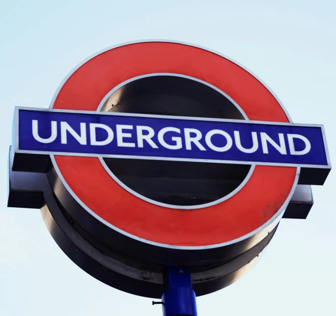 an underground sign for the train station, with blue lettering