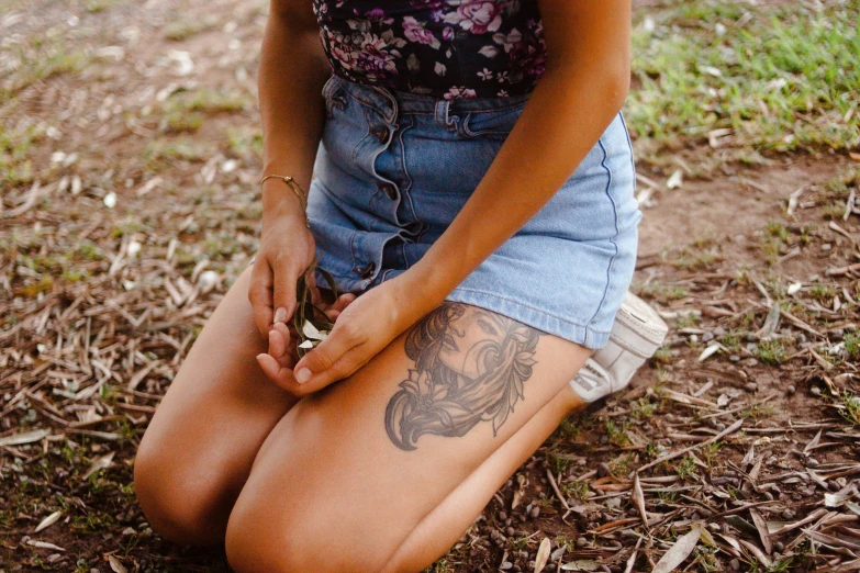 a tattooed girl sitting on the ground
