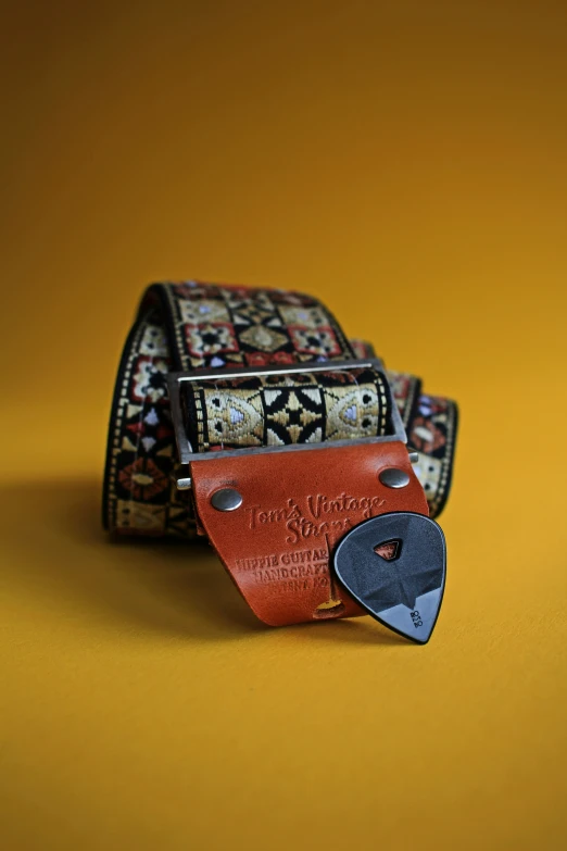 the belt is covered with multicolored fabric and has a metal buckle