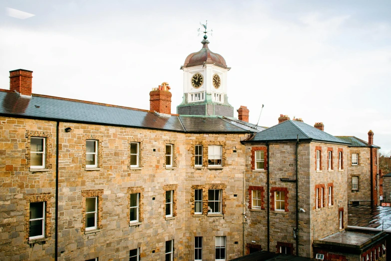 a stone building with a clock tower near the roof of it