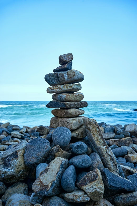 rocks are piled up to make an interesting pyramid by the water