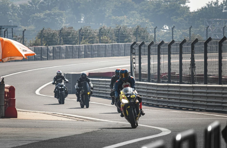 there are three people riding motorcycles around the track