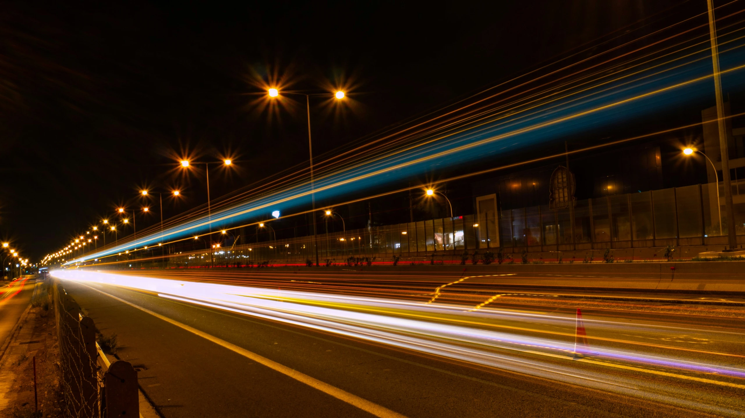 car lights streak through the street at night