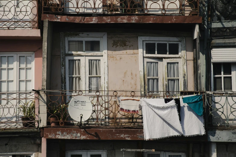 clothes are hanging on a line and outside an old building