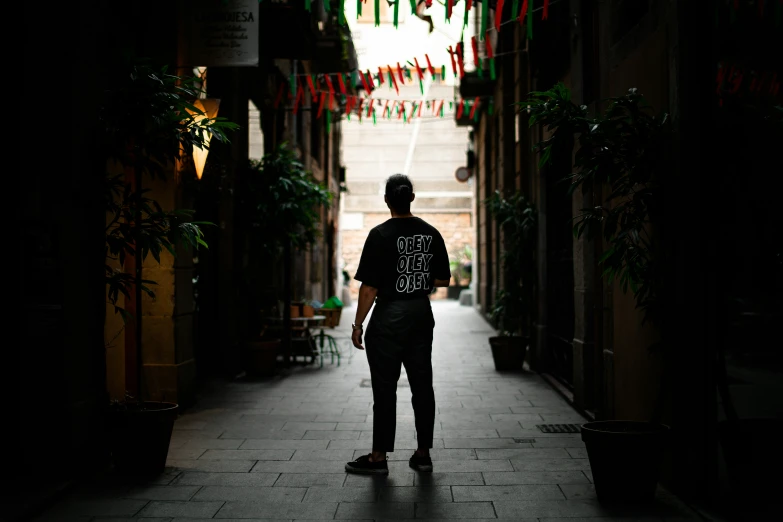 the man is standing in the alley way looking down