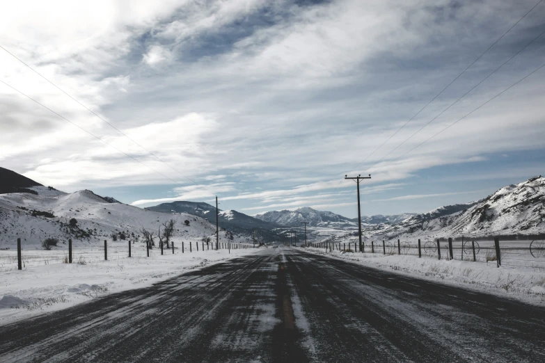 a long empty road with lots of snow