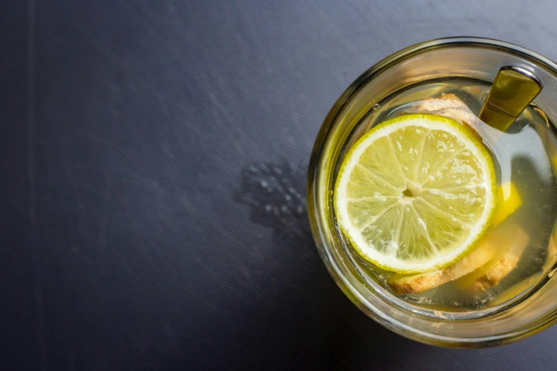 a glass mug with a lemon and ice inside