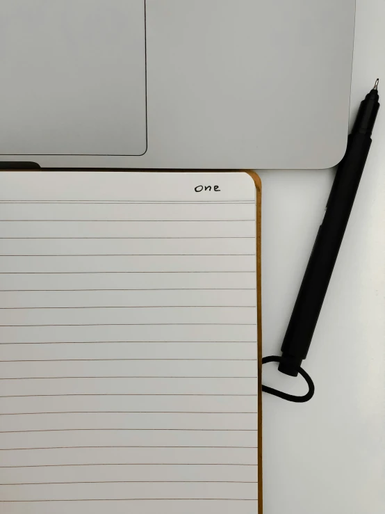 notepad with an apple keyboard next to a desktop computer