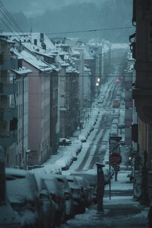 a snowy, street in the middle of an urban area