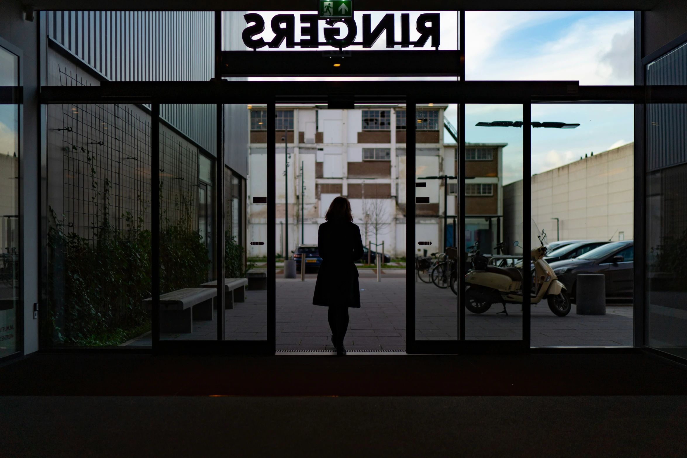 a woman is standing outside of an entrance into a building