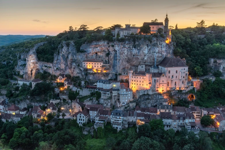 a cliff town lit up at night