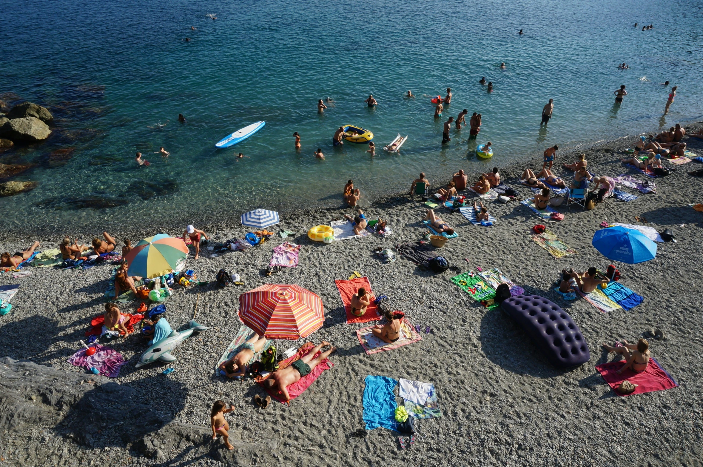 some people in their bathing suits, swim trunks and umbrellas on the sand