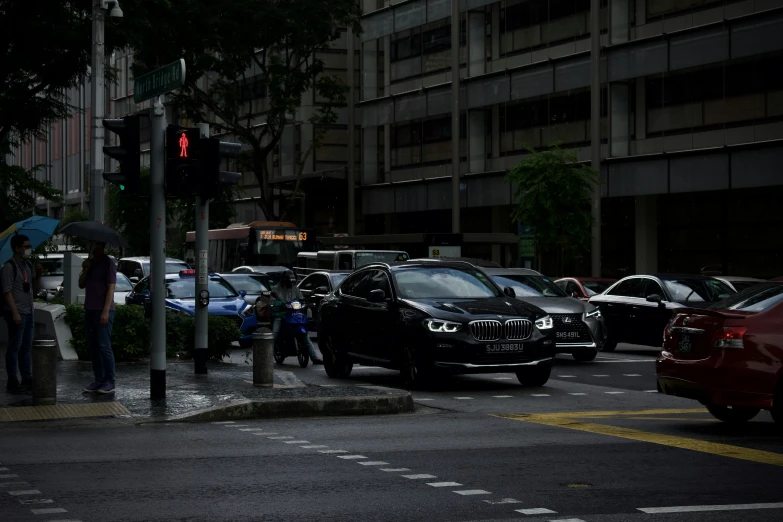 traffic waits to cross at a crosswalk for pedestrians to go