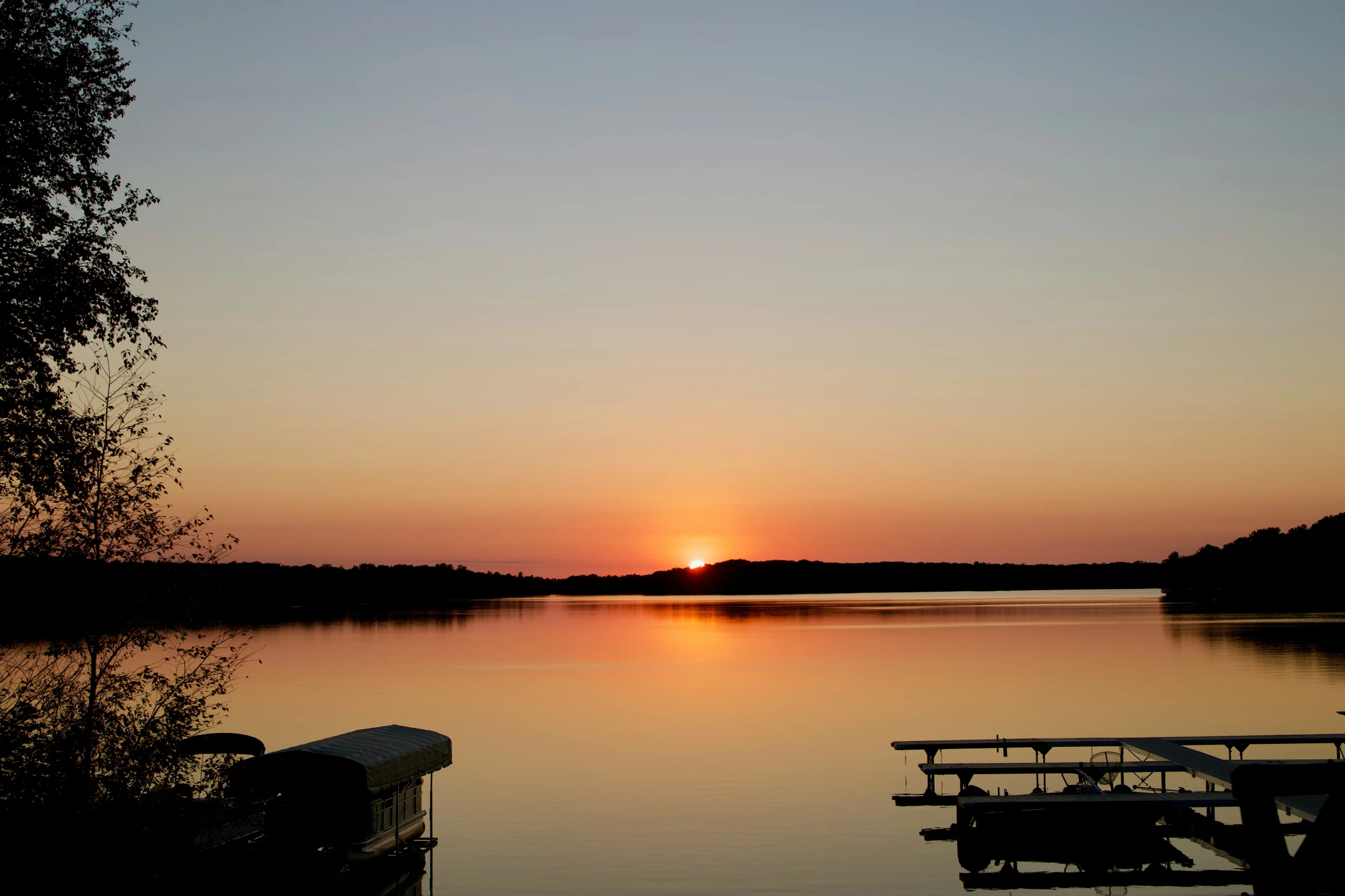 the sun is setting over the water at this lake