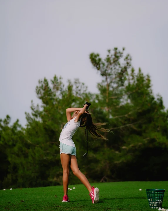 a young lady playing with a red tennis racquet