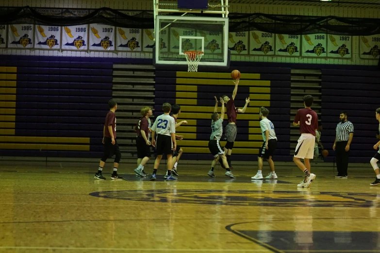 a group of s playing basketball in a gymnasium