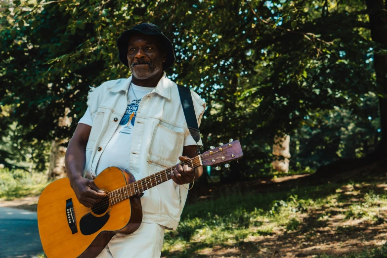 a man is playing the guitar in the grass