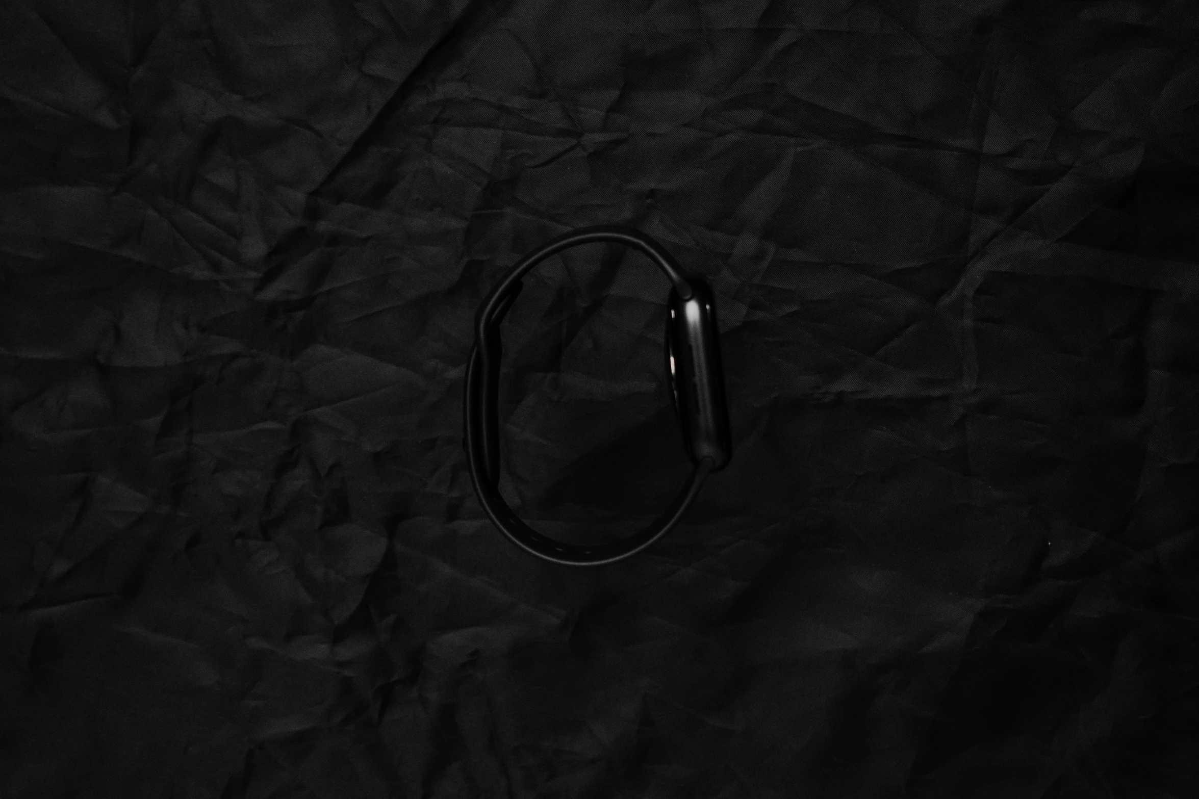 a black metal object lying on a black paper background