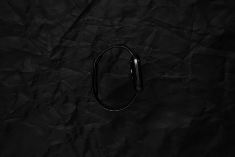 a black metal object lying on a black paper background