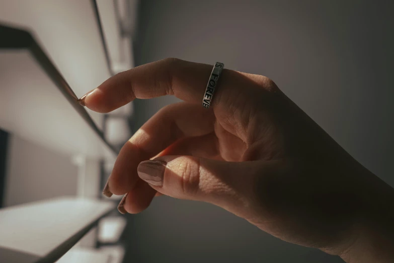 a person holding a cigarette near a small shelf