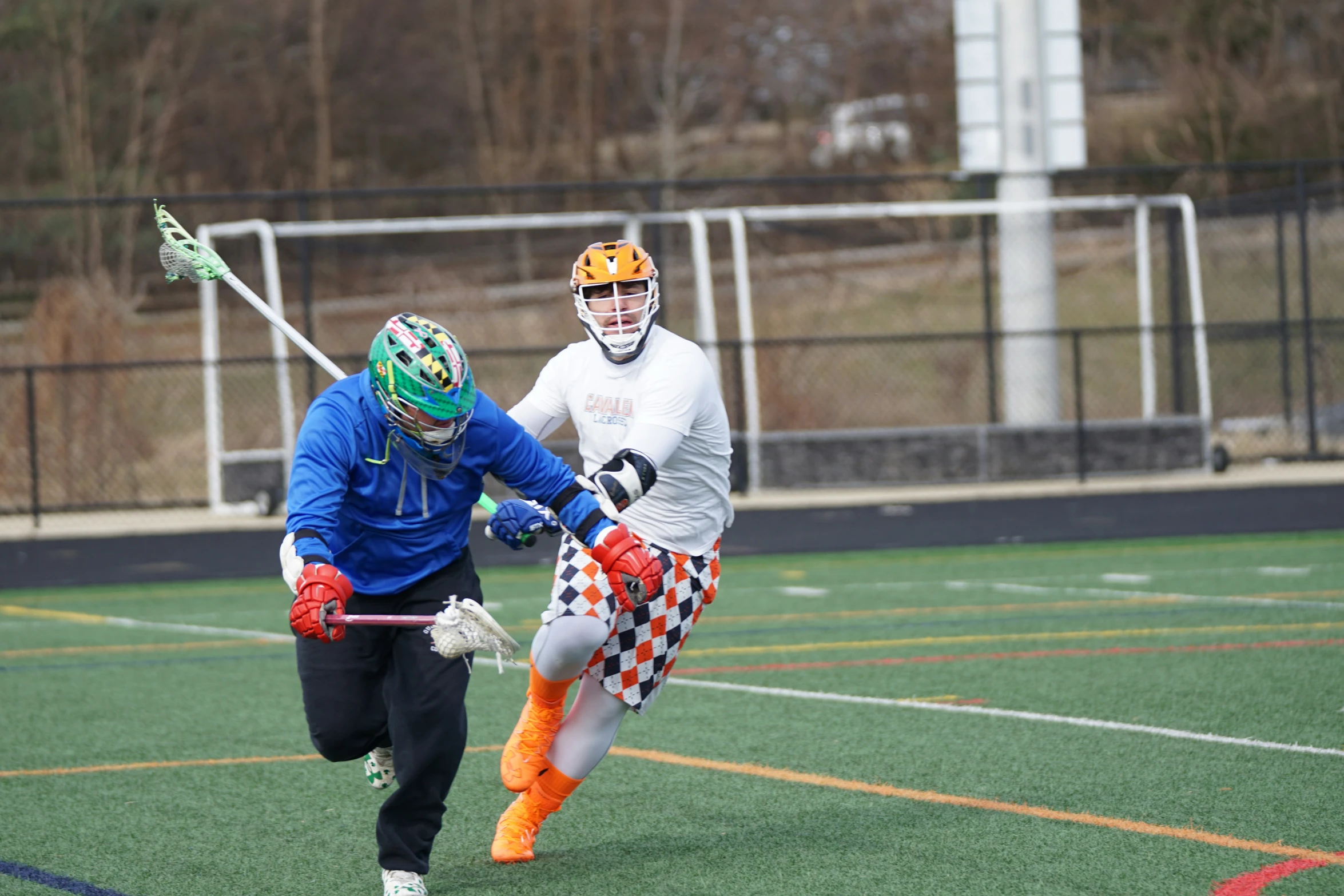 a young man playing a game of lacrosse on a field