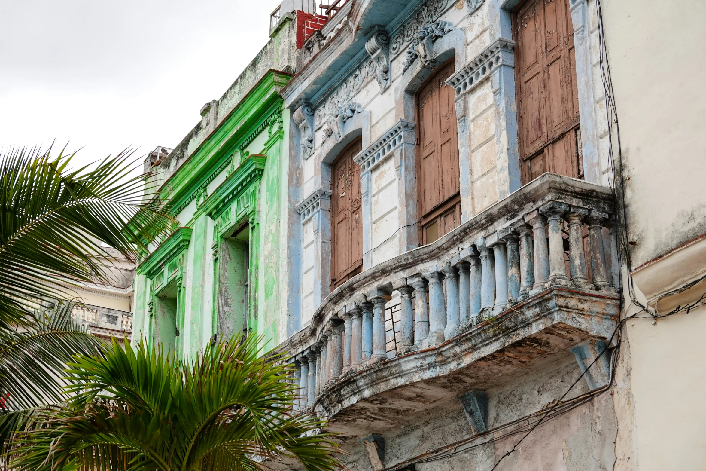 a few buildings on a city street in front of palm trees