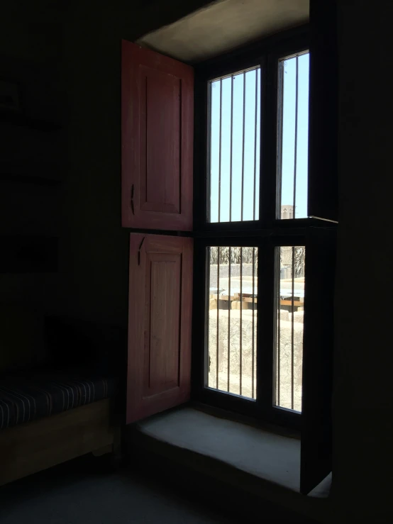 a room with shutters, a bed and some shelves