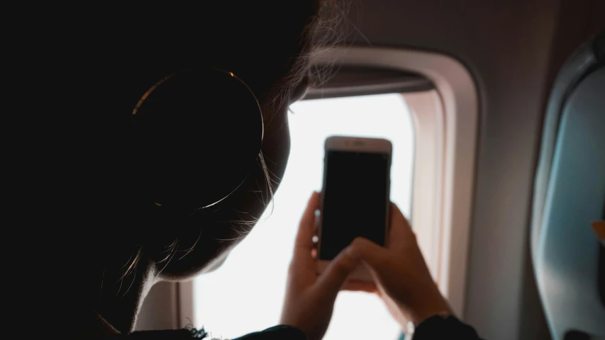 someone using a cell phone on an airplane