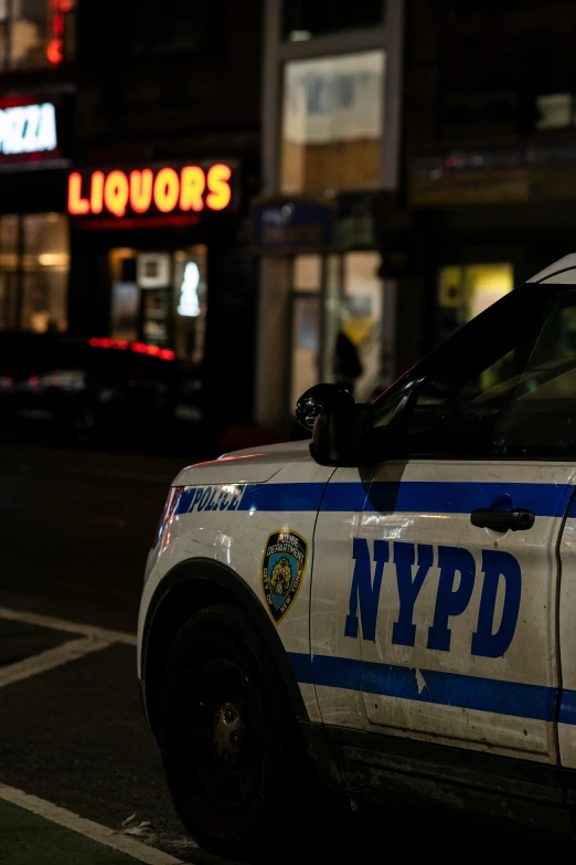 an nypd police car parked at the curb of a street