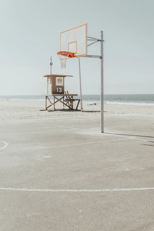 an empty basketball court with a man looking at the basket in front